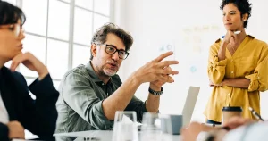 A project manager attempting to lead a meeting with a team of three other people